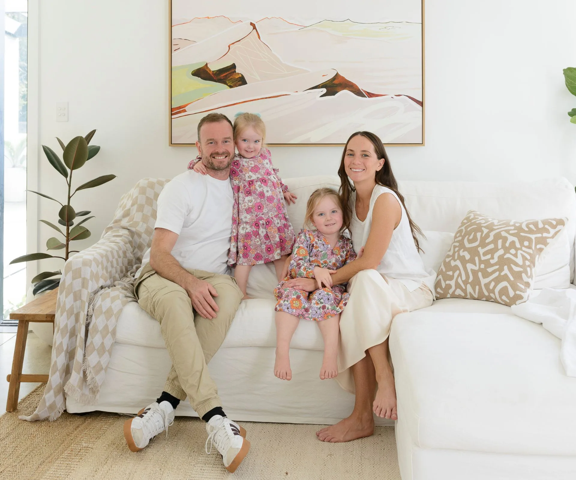 The Pakuranga new-build owners and their daughters sitting on the couch