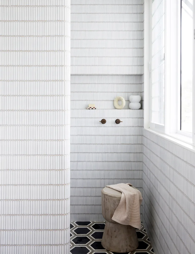 A small bathroom with white tiled walls