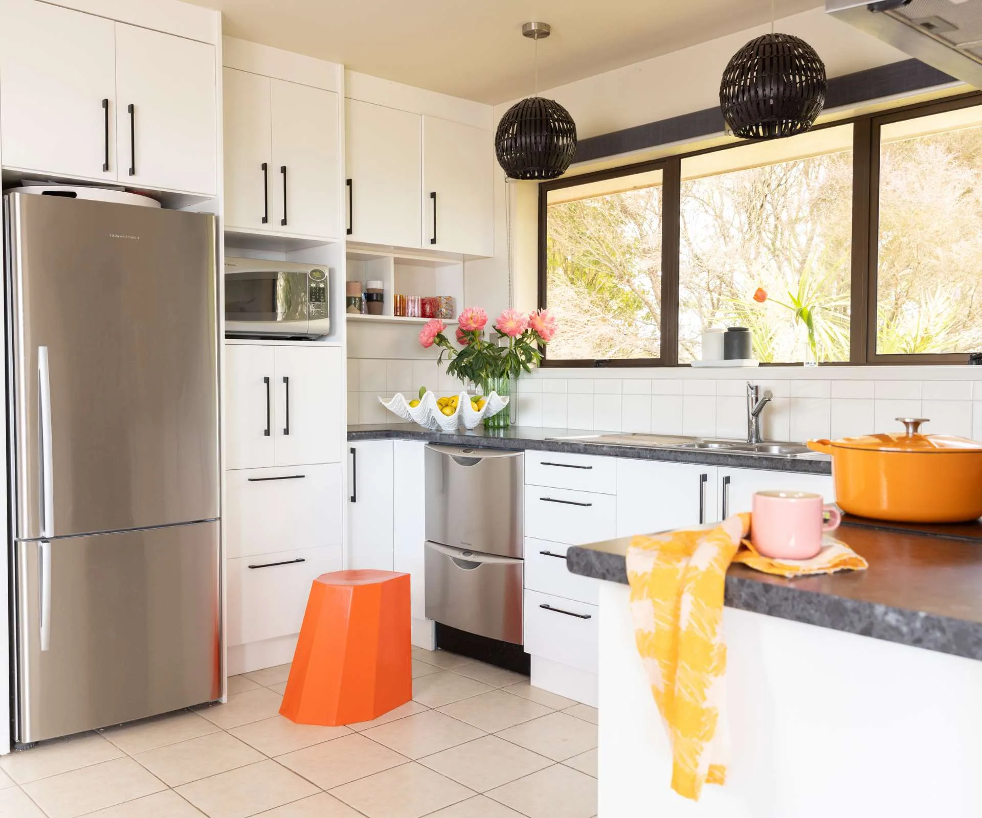 A plain kitchen with an orange circus stool