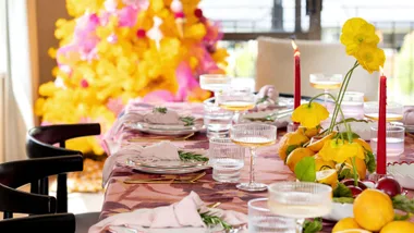 A table setting with a yellow Christmas tree in the background