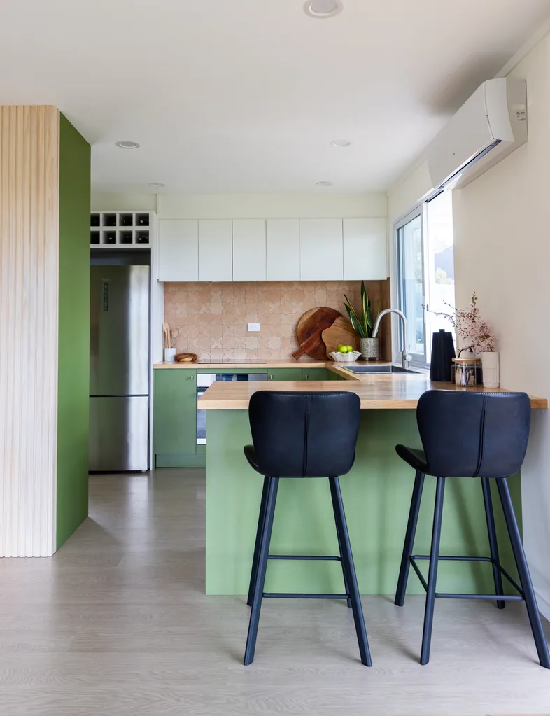 Green kitchen in the dwelling renovated by the Pearsons