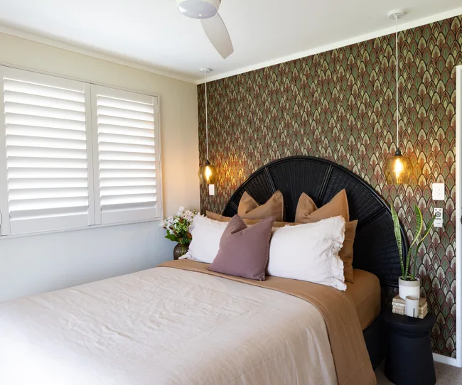 Main bedroom in Pearson renovated home. Feature wallpaper continues the green theme