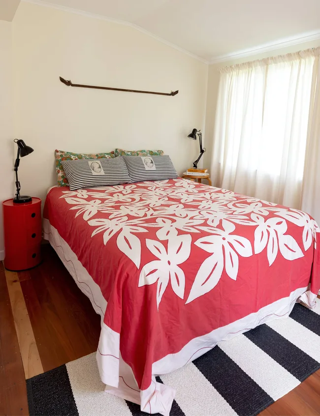 The master bedroom with a bright red duvet cover across the double bed