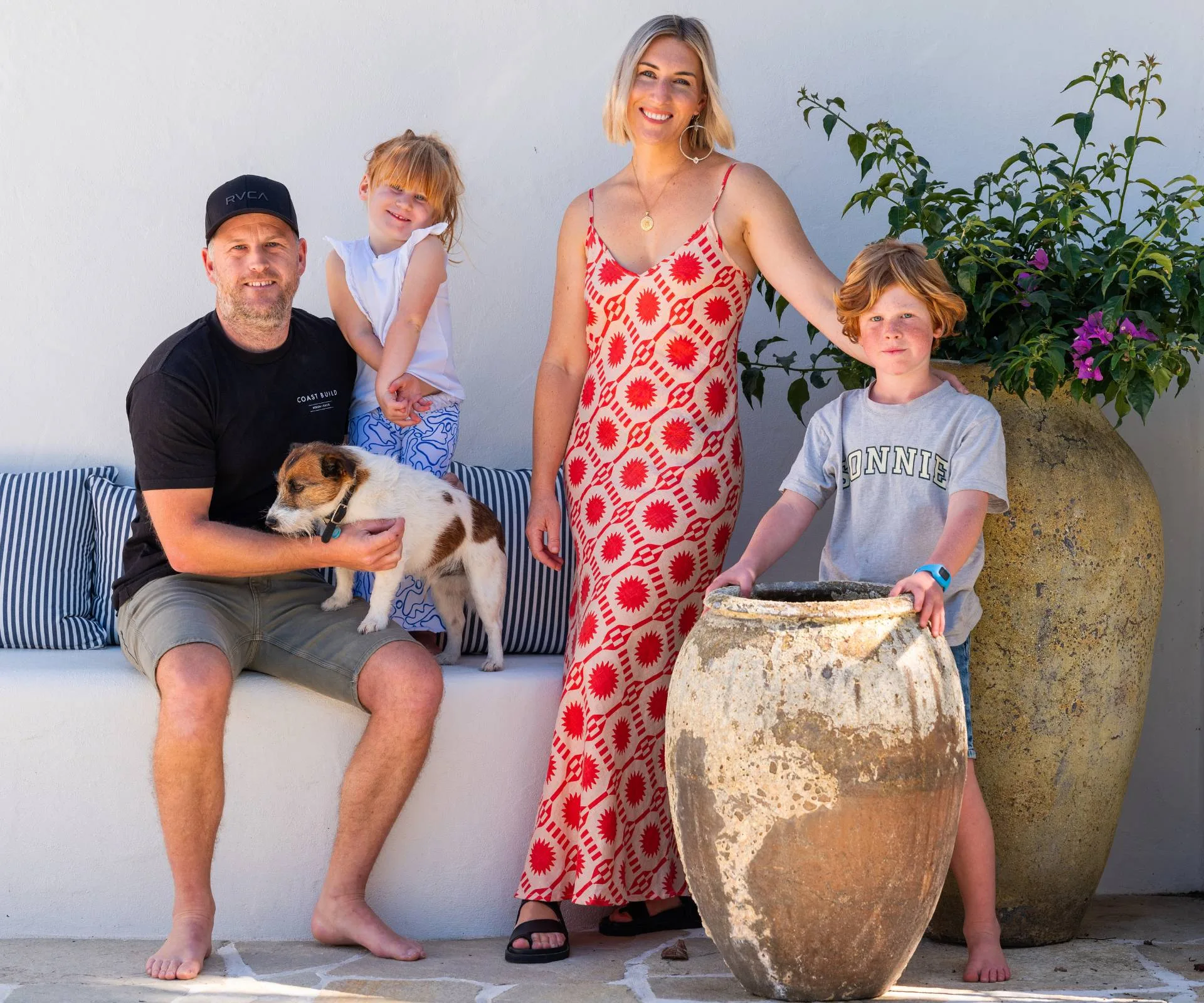 Wainui Beach bungalow homeowners Kate and Tim outside with their kids