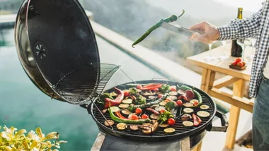 Man barbecuing next to swimming pool