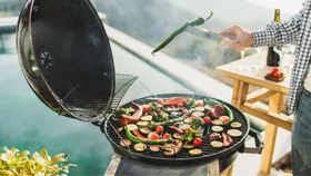 Man barbecuing next to swimming pool
