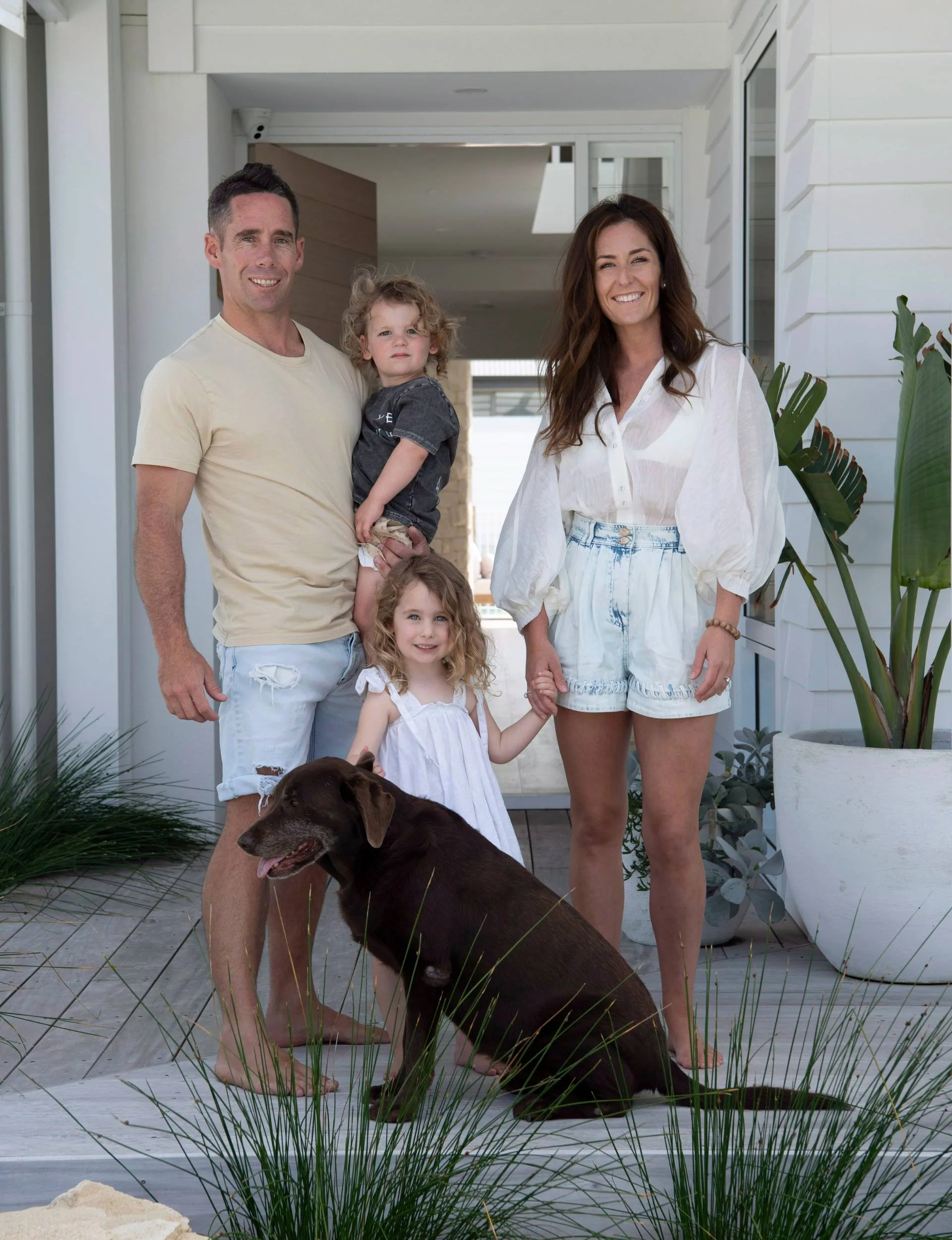 Hamptons-style home owners Kristie and Andrew standing in front if the front door with their kids