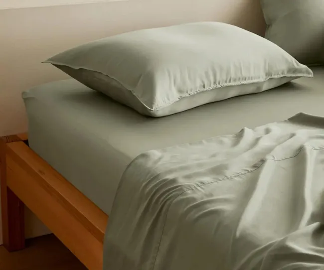 Sage green sheets and pillow on bed