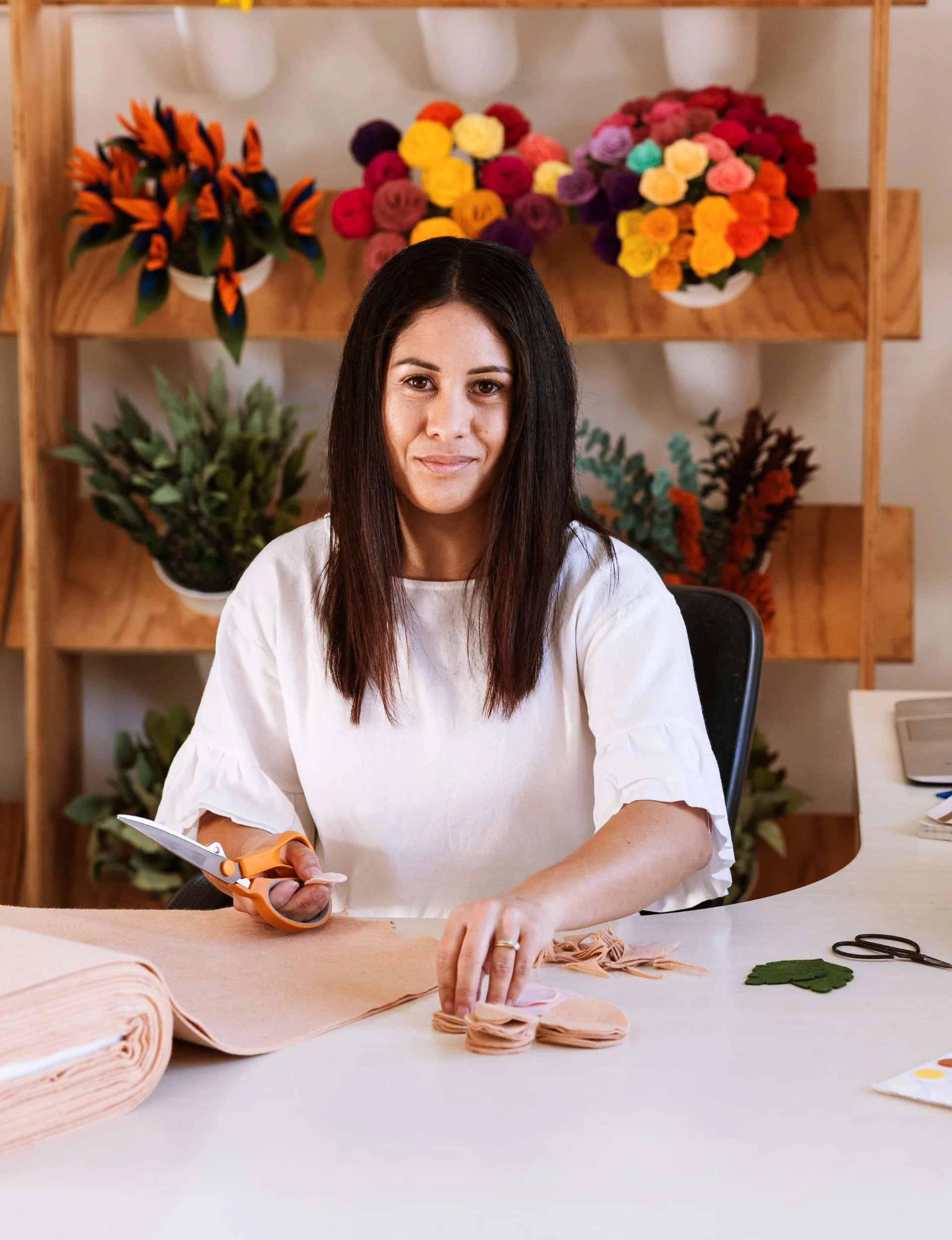 woman sitting cutting felt 