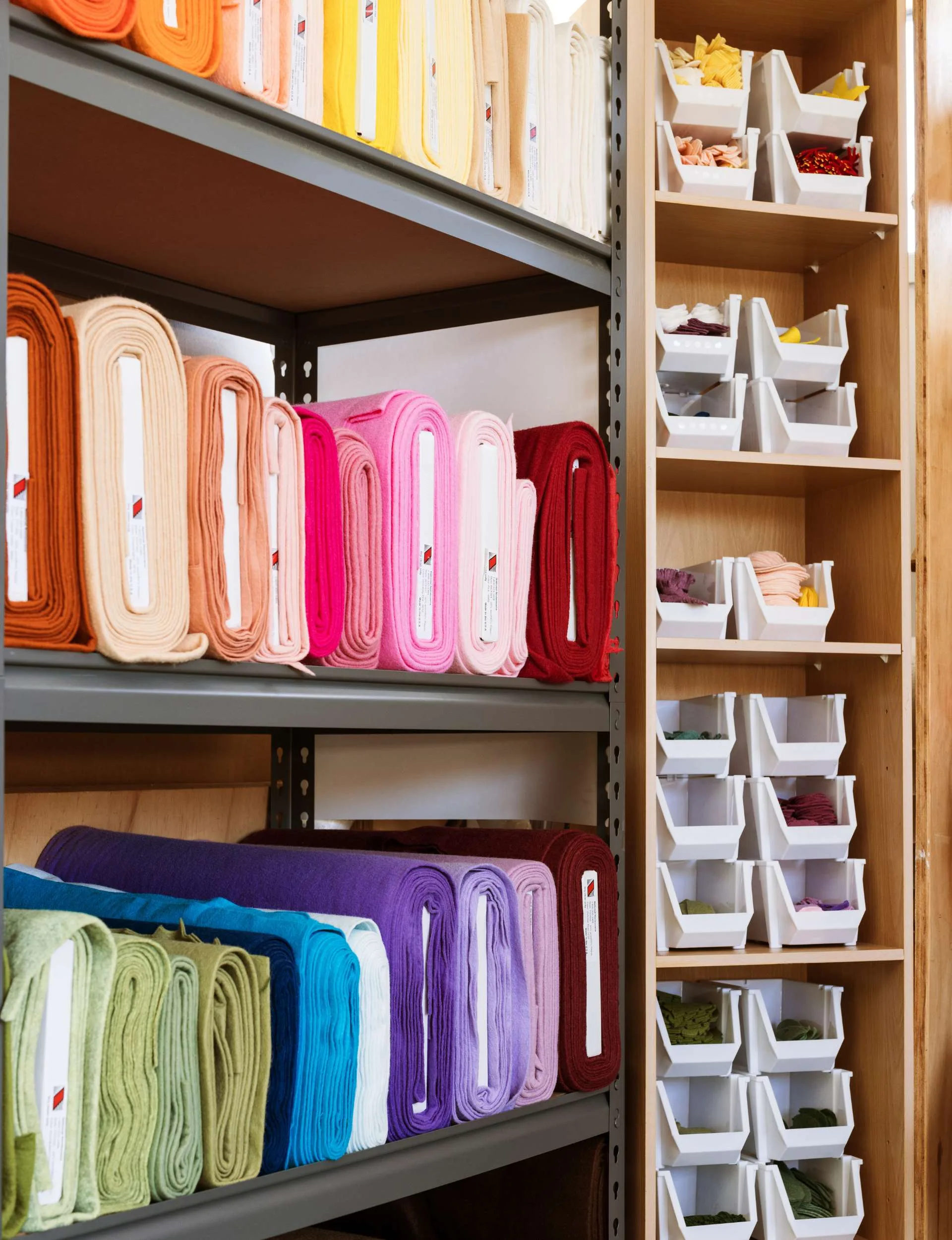 Different clours of felt rolled up sitting on a shelf