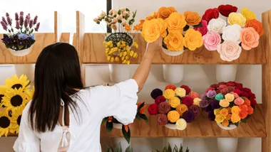 Fabric flowers on stands with woman picking a bunch