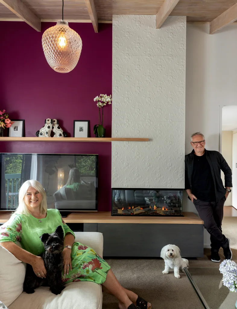 Homeowners Nic Hall and Kiri Chivell in their living room with plum feature wall