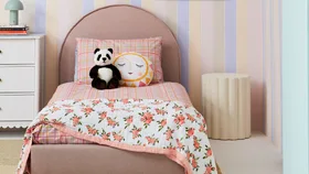 Kids bedroom using pastel colours throughout featuring a pastel striped wall