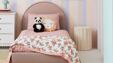 Kids bedroom using pastel colours throughout featuring a pastel striped wall