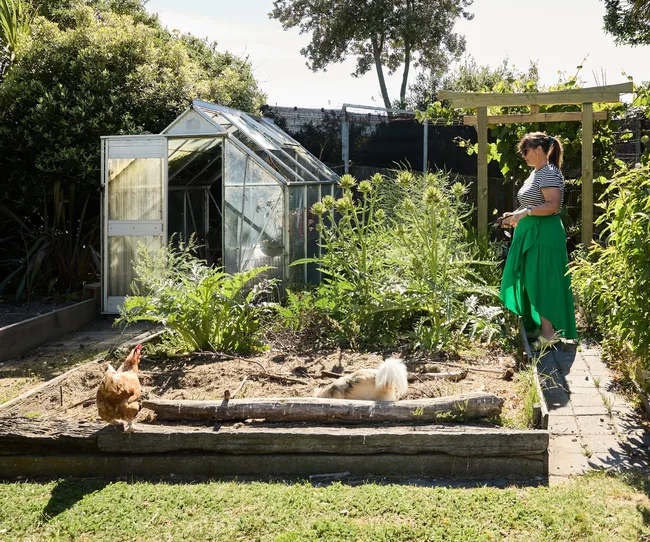A woman tending to her planter box in the back yard