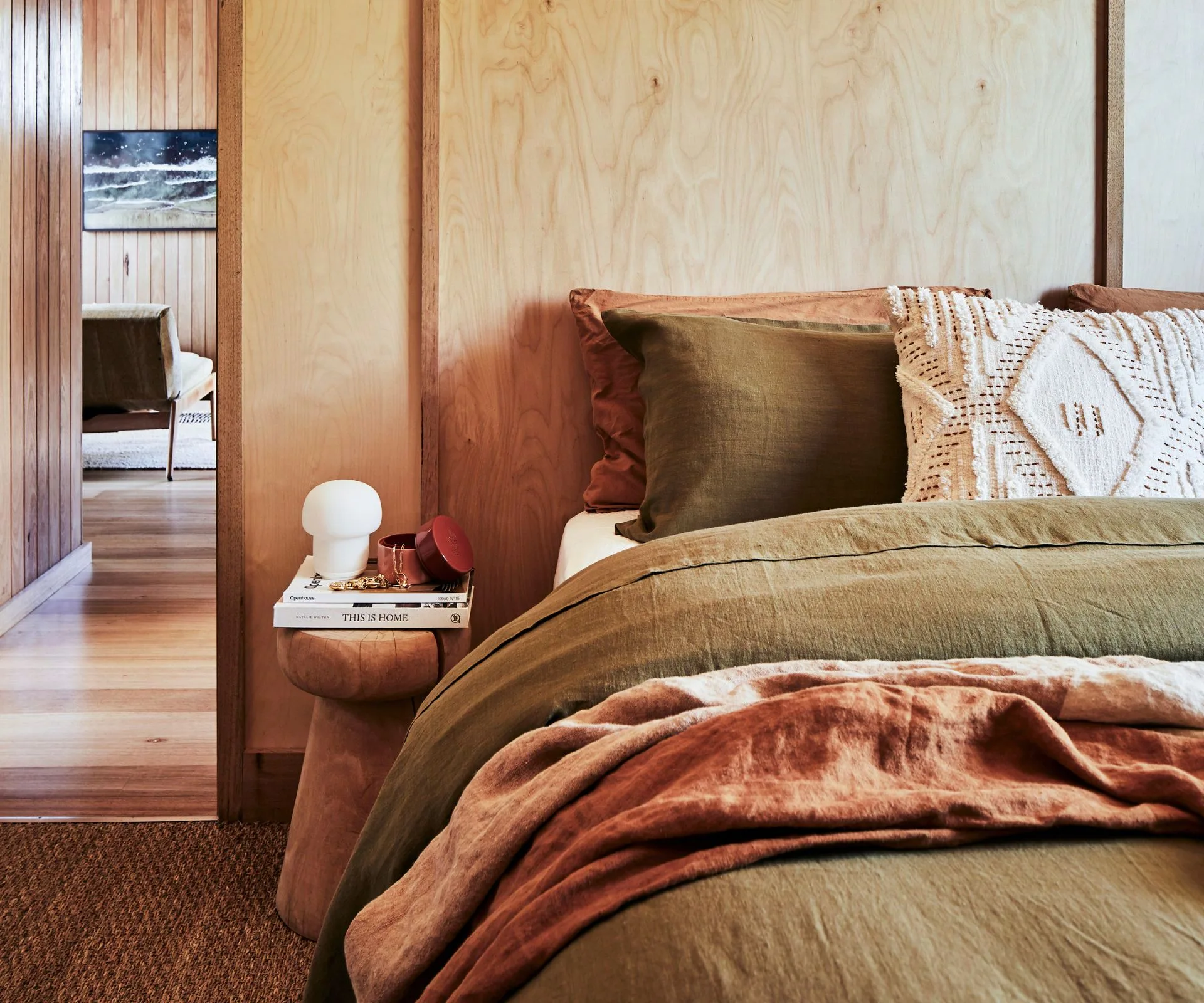 A first plain main bedroom with wooden walls and green bedding