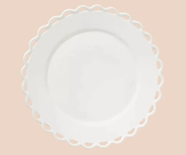 White dinner plate against a pink background