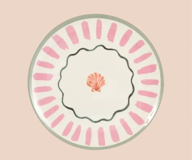 A tropical themed plate against a pink background
