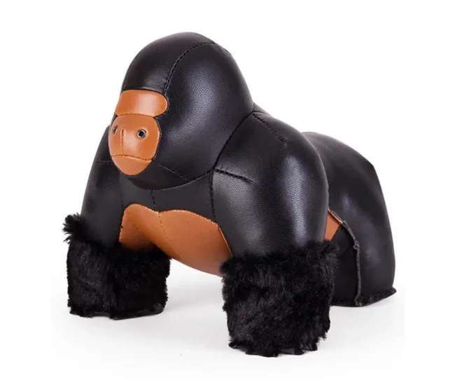 Leather gorilla figurine with black fur legs and brown face, standing on all fours.