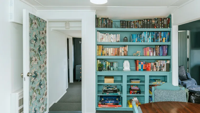 Bookshelf painted in Resene Juniper, a blue colour.