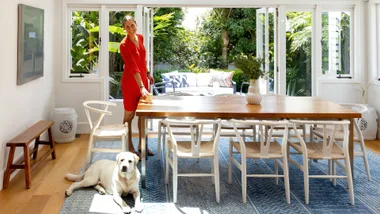 Kady stading at the head of the dining room table in her 1920s Auckland home