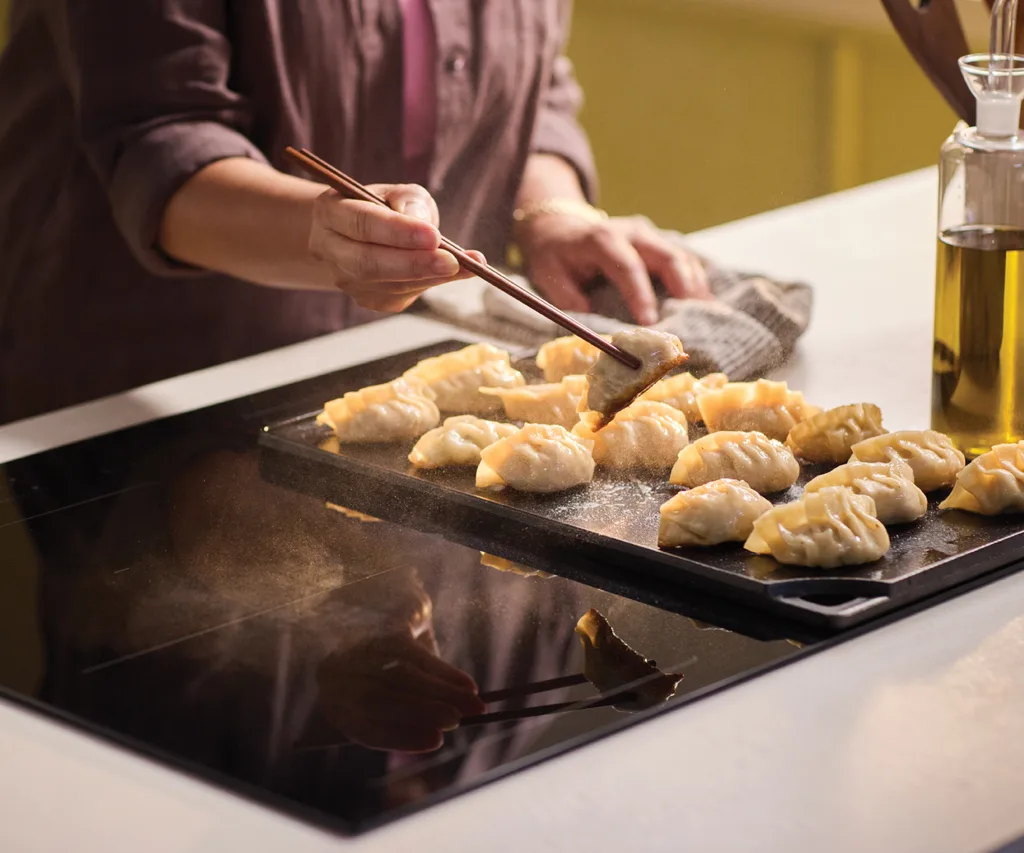 Lady cooking dumplings on a Haier induction cooktop
