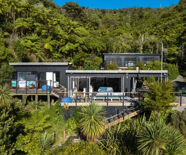 A three tiered home surrounded by bush