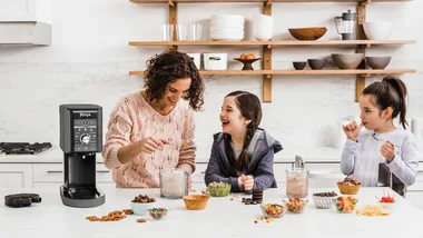 A mother with her two daughters making ice cream in a kitchen