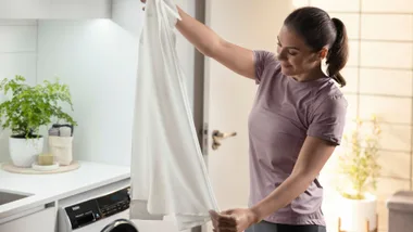 Lady holding a shirt doing laundry