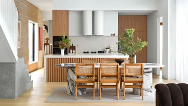A kitchen with white, wooden and rattan features