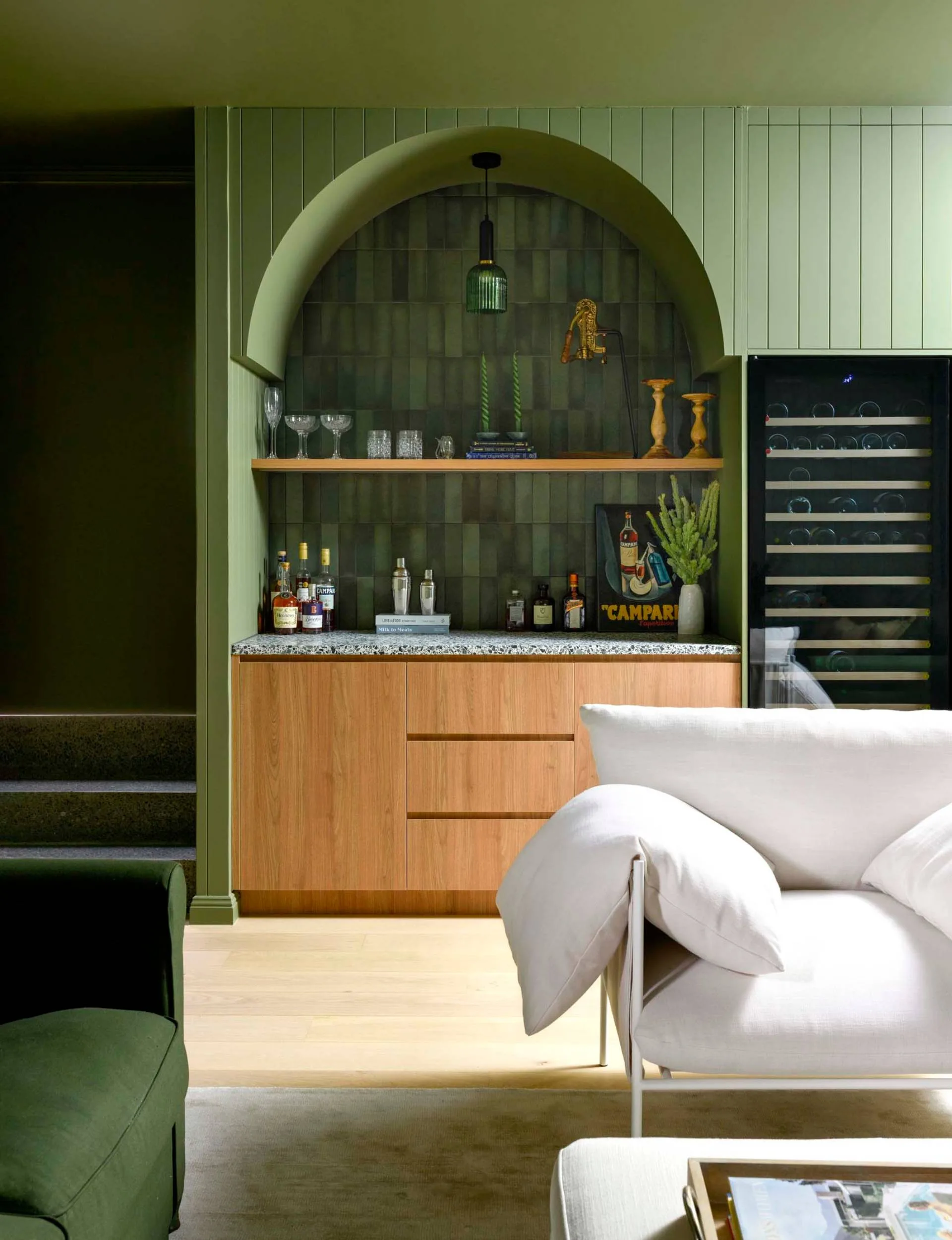 Olive and white furniture in an olive painted mid-century-inspired underground media room