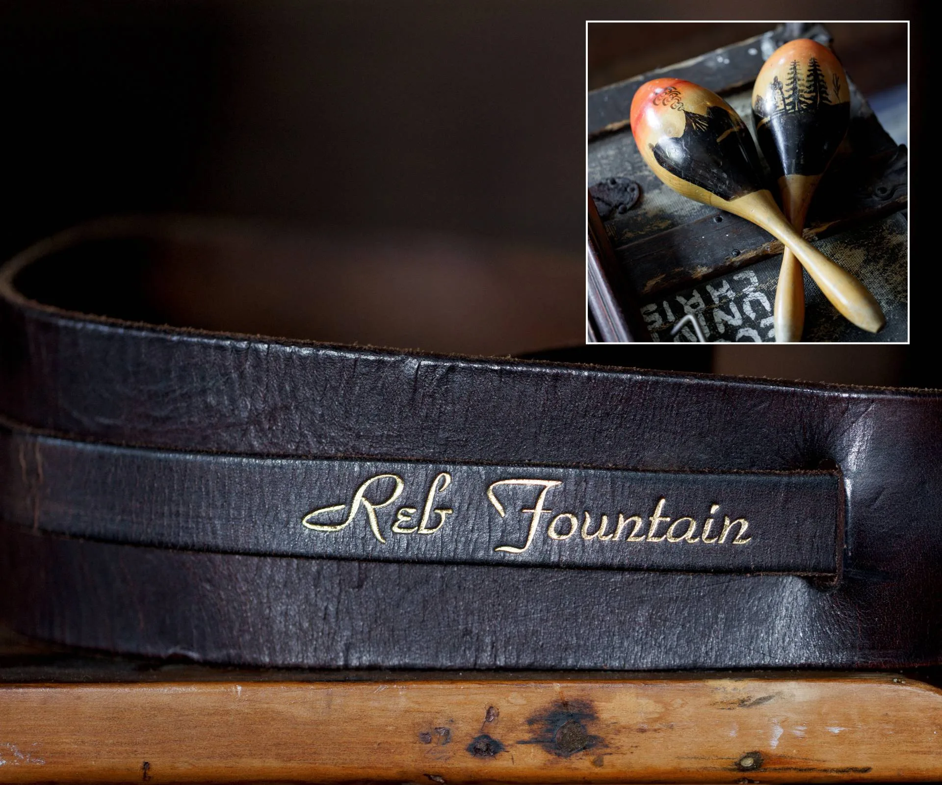 'Reb Fountain' embossed into a black leather guitar strap with old maracas