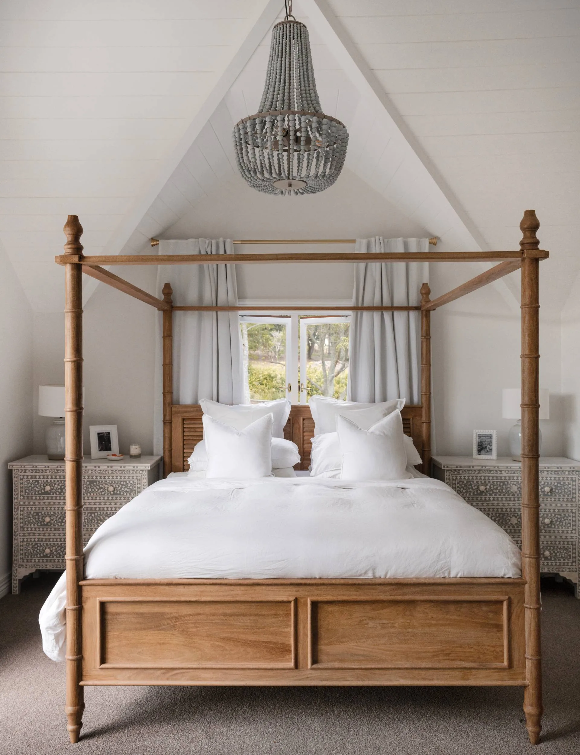 A bedroom with white walls and a large wooden bed frame