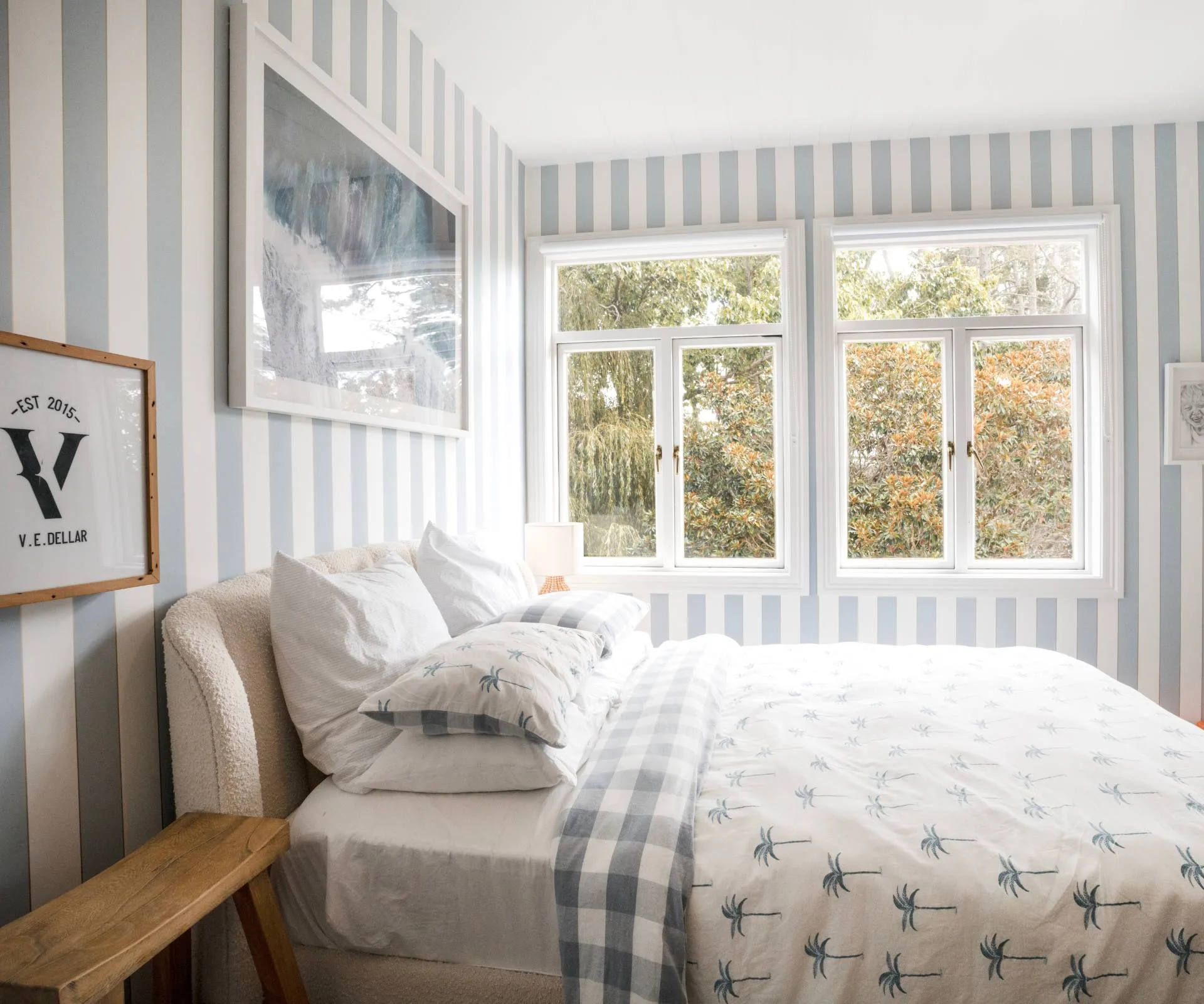 A bedroom in the Auckland homestead with vertical blue and white wallpaper