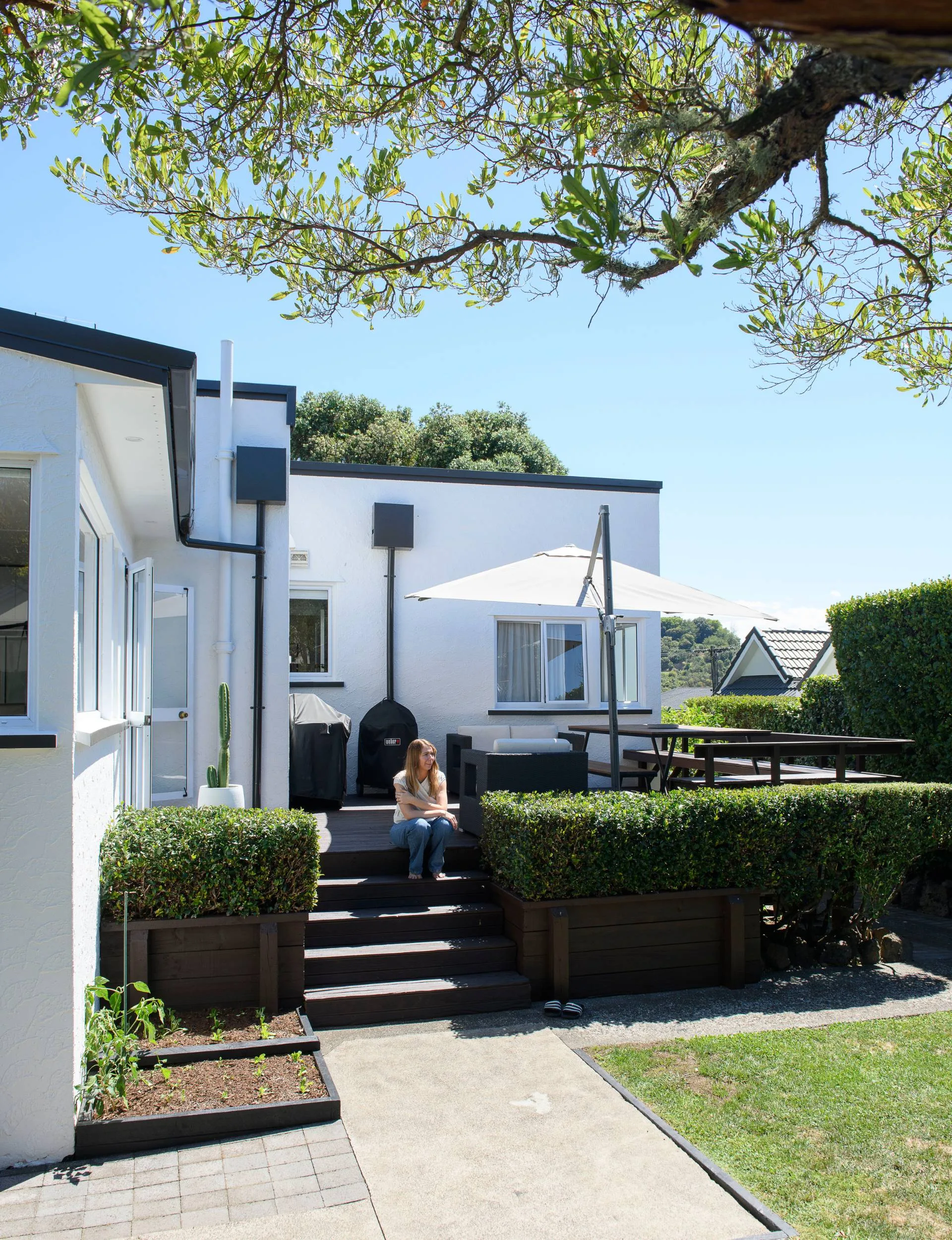 Melissa sitting on the outdoor steps of the Epsom art deco&nbsp;home