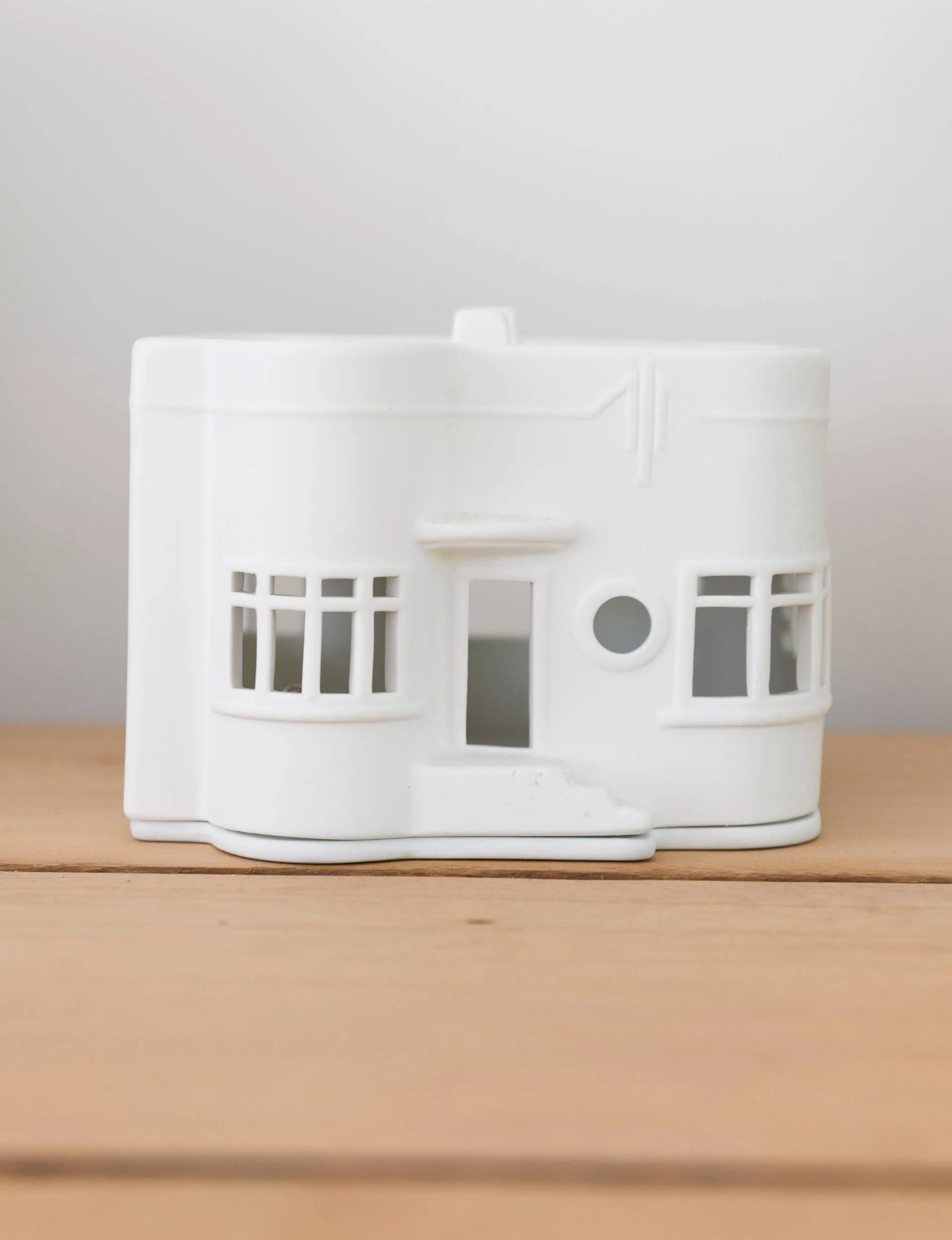 A small white house trinket sitting on the office desk