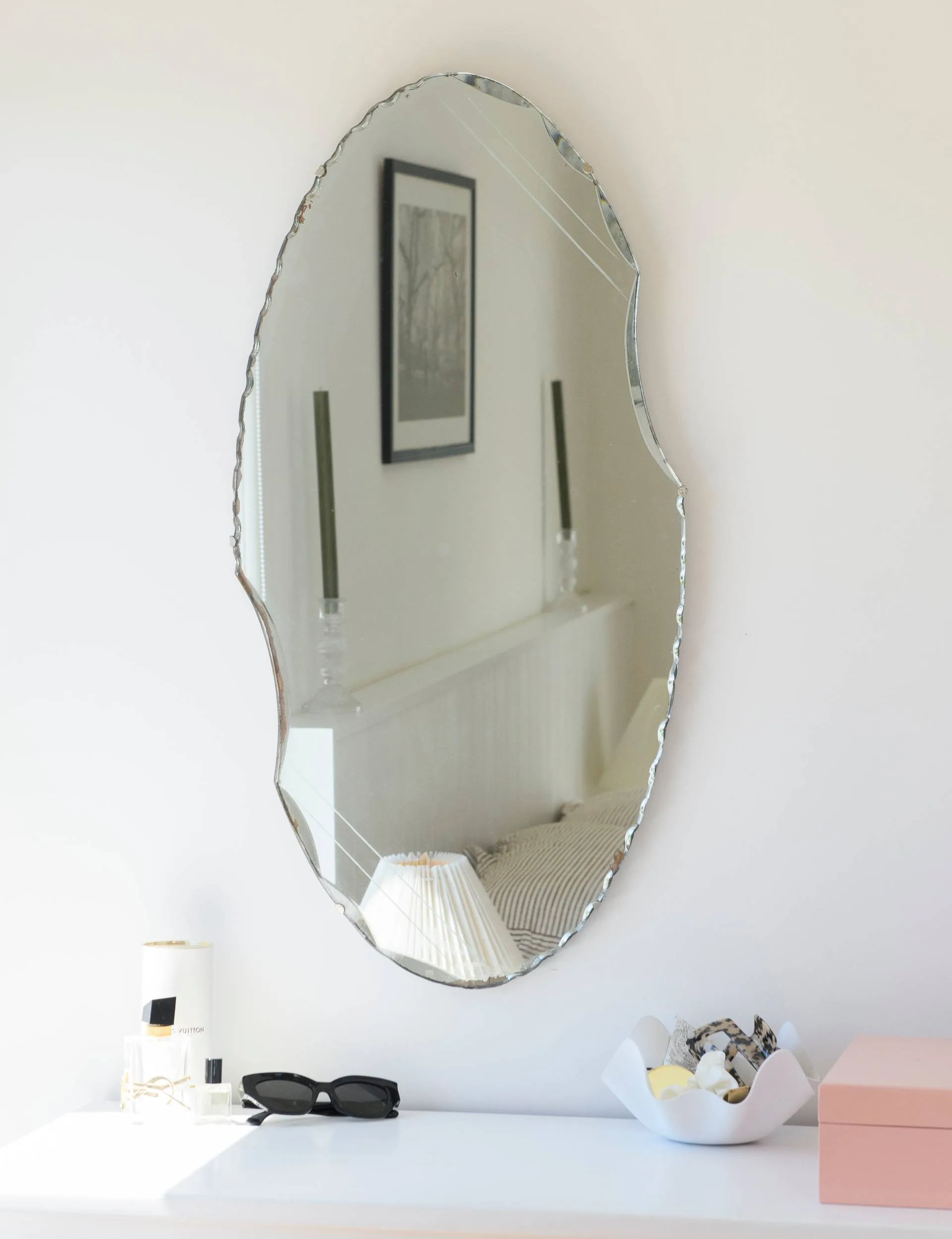 A scalloped oval mirror in the bathroom