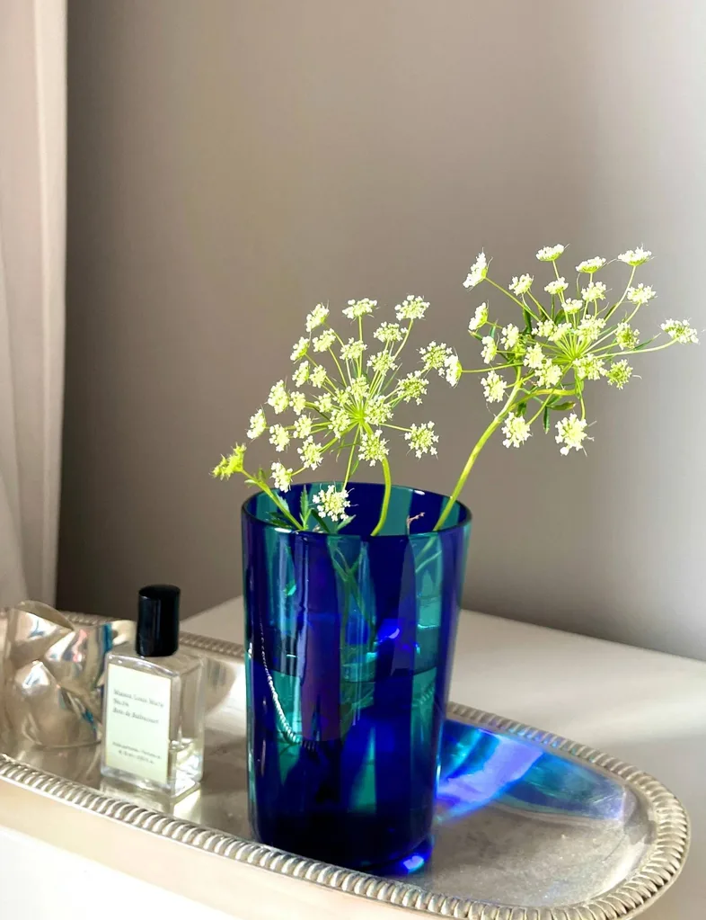 A blue striped vase with flowers inside.