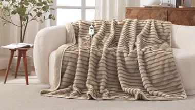 Heated throw blanket on cream couch