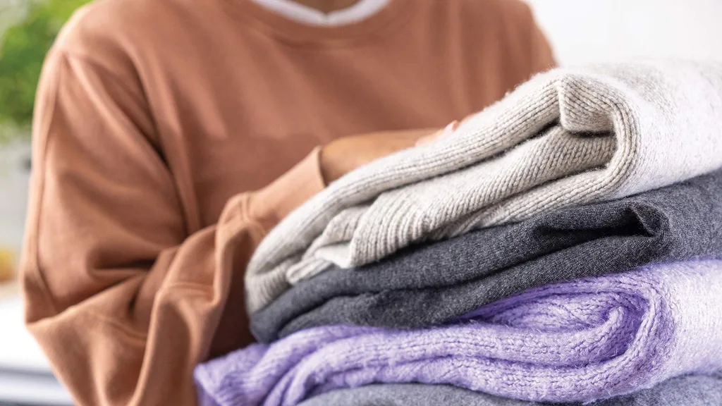 Lady holding stack of laundry