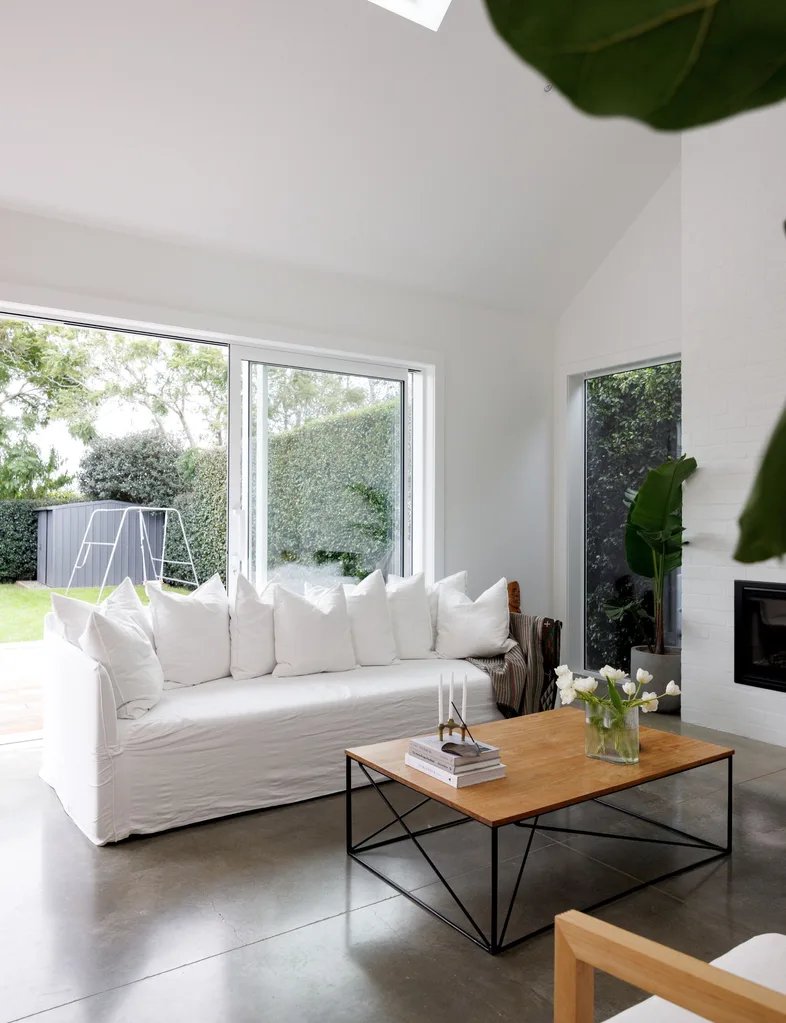 The living room of the Devonport villa with concreate floors and white couch