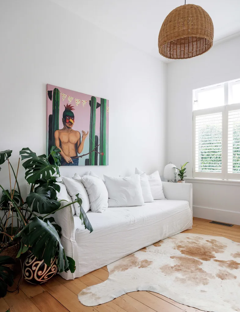 The second lounge with white walls, white couch and original wooden floors