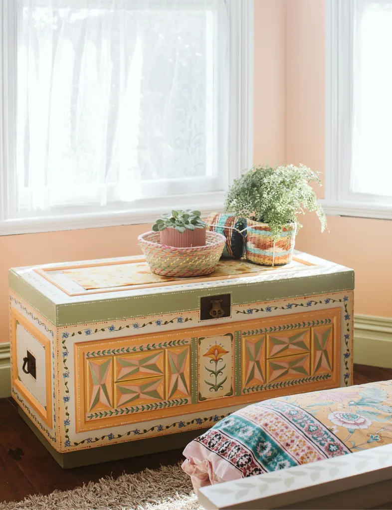 Blanket chest painted in green and sunset colours, inspired by folk art