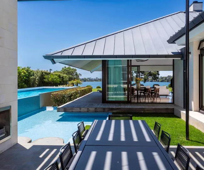 Looking through a modern home with a pool on the left
