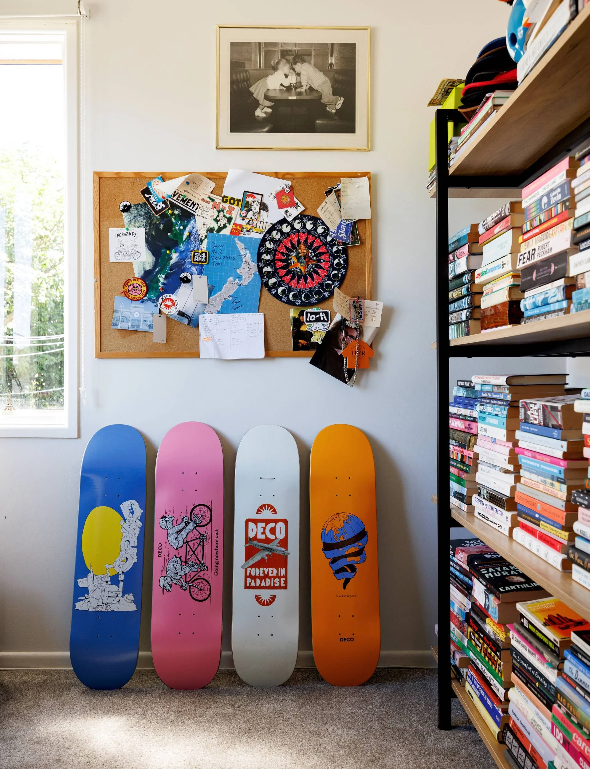 Decorated skateboards beside a bookshelf