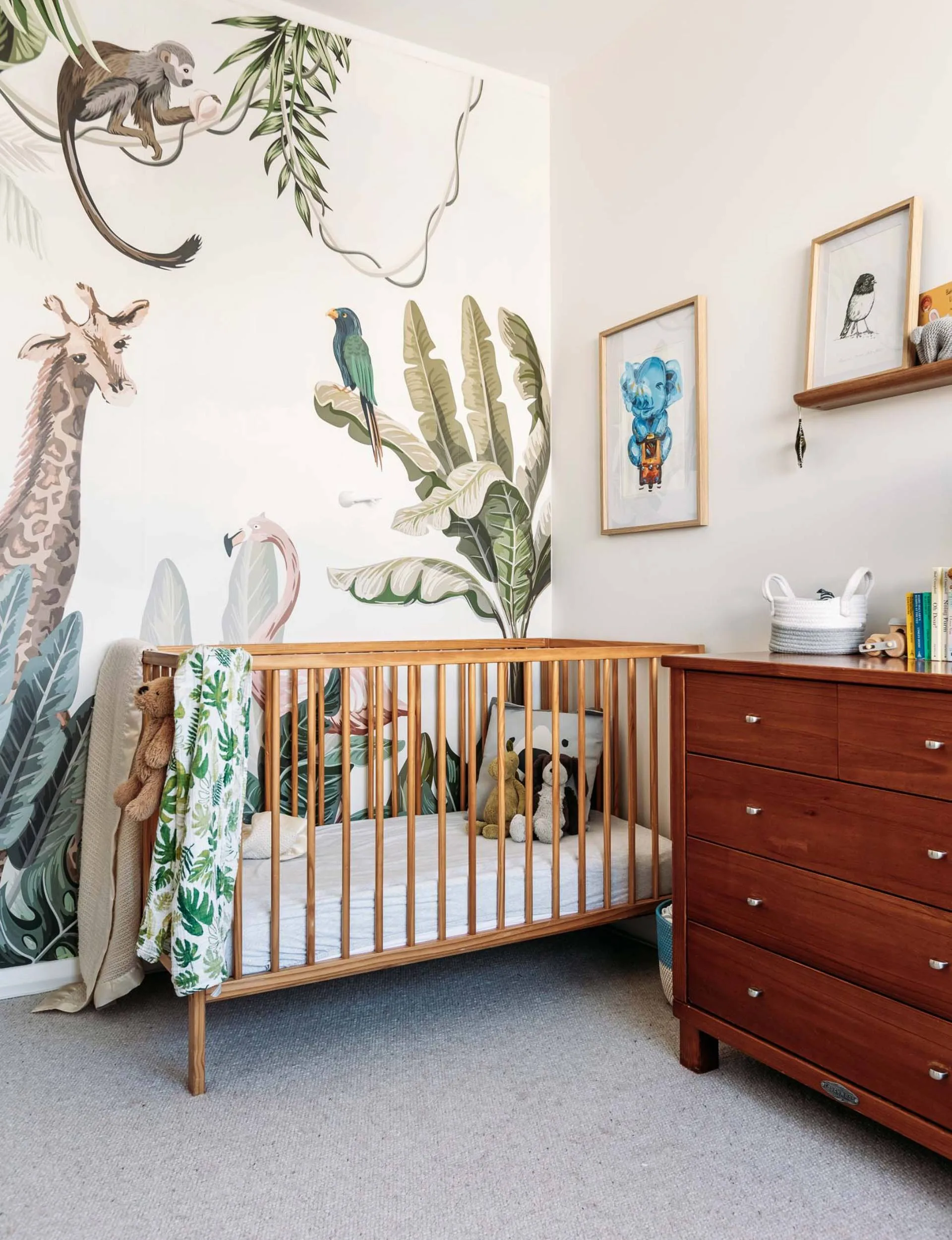 A wall-wide forest mural behind the cot in the nursery of the renovated Wellington home