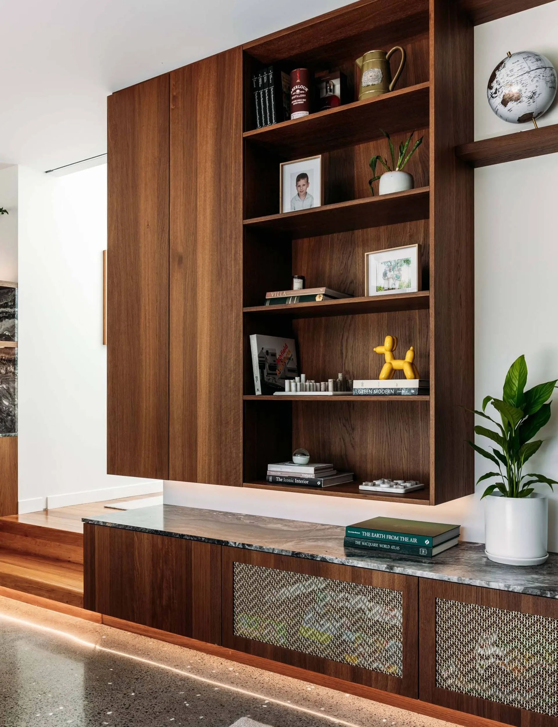 A large oak bookshelf mounted around the TV in the renovated Wellington living room