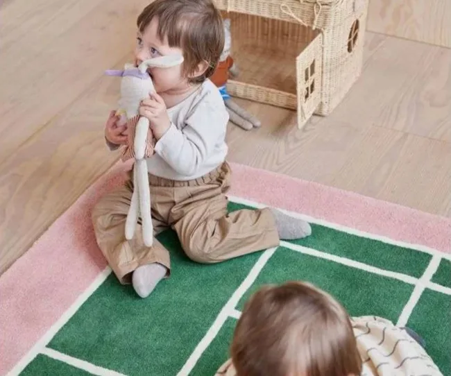 Tennis court print rug with two toddlers playing