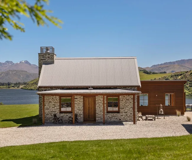 A stone cottage on the edge of a lake