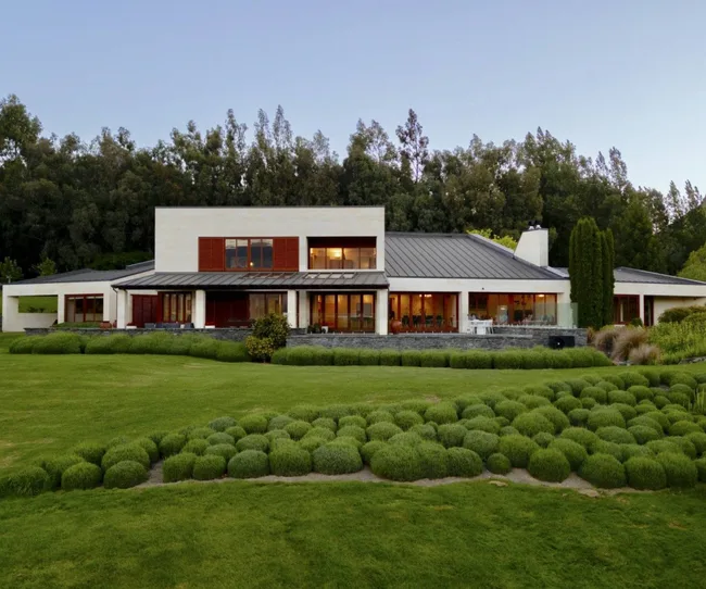 A white, double-storey home in a field